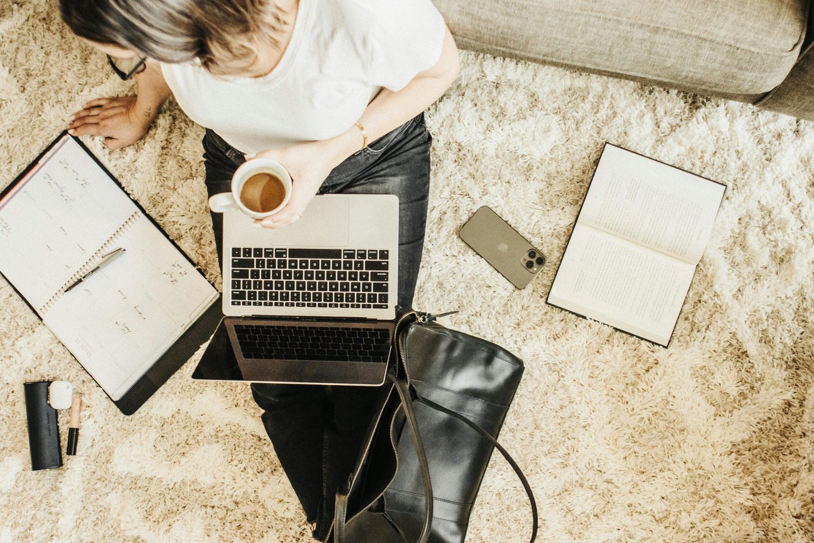 Cozy workspace setup with a laptop, planner, and coffee, ideal for remote work inspiration.